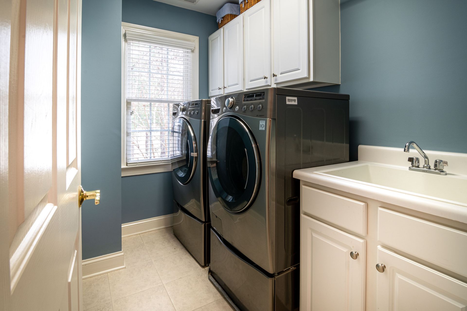 A clean, organized laundry room featuring modern appliances and ample storage.